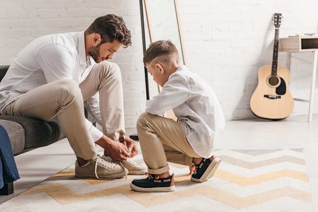 BCBA helping child to learn to tie his shoes