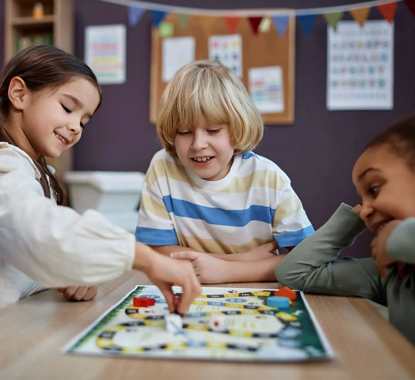 Children playing a board game together during a social skills group at Meredith School in Queen Village
