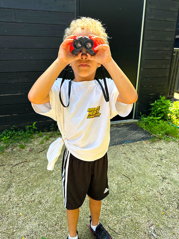 Camp kid exploring outdoors with binoculars in Philadelphia