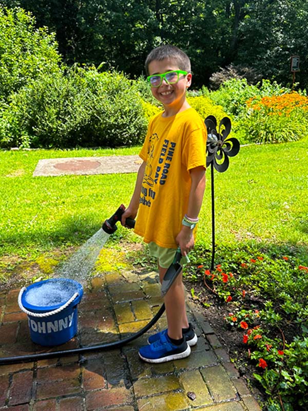 Camper learning independence skills while gardening at ELBA summer camp in Philadelphia