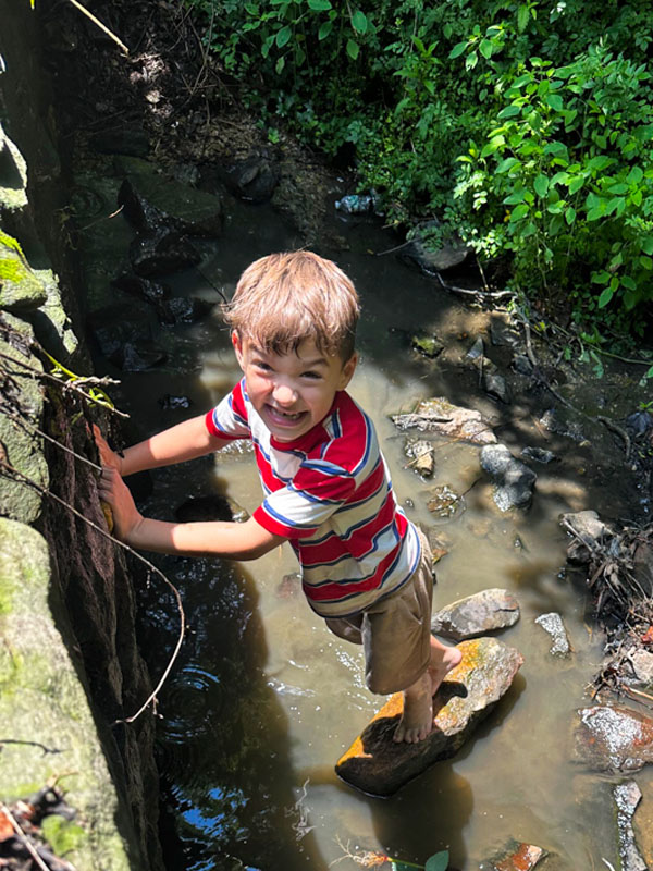 Kids exploring a creek during a summer camp outdoor activity